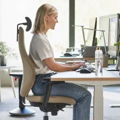 Kobieta pracuje przy biurku, skupiona na klawiaturze. To obraz nowoczesnego biura, gdzie praca biurowa jest priorytetem, a nie produkcja.