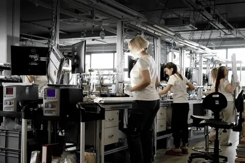 Pracownicy stosują zasady lean management na linii produkcyjnej, optymalizując procesy.