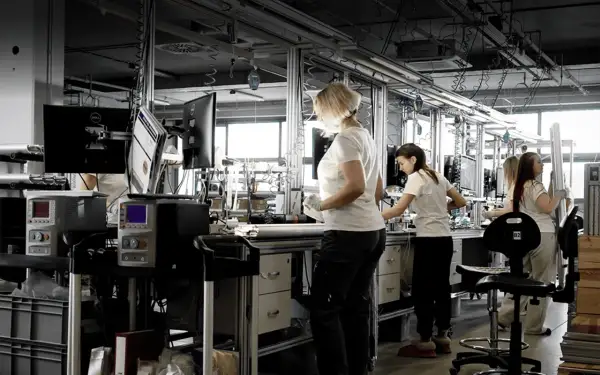 Pracownicy stosują zasady lean management na linii produkcyjnej, optymalizując procesy.