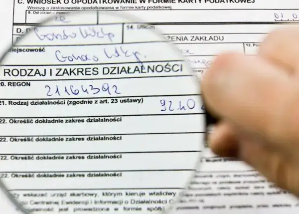 Formularz podatkowy z lupą. Analiza podatek liniowy a VAT, wpisany REGON i rodzaj działalności.